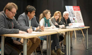 Familiares de las víctimas posan con una de las piezas de la exposición que complementa las jornadas en el centro cívico La Ranilla. / Foto: J. M. Paisano