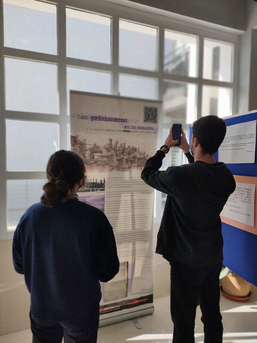 Un alumno del instituto Getares de Algeciras saca una foto con su móvil a uno de los paneles de la exposición.