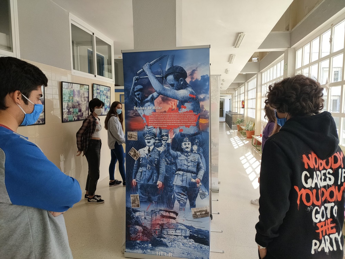 Varios alumnos de un instituto de Algeciras leen el panel en el que se explica la relación de las obras de fortificación del Estrecho con los planes de guerra de Hitler y Franco.